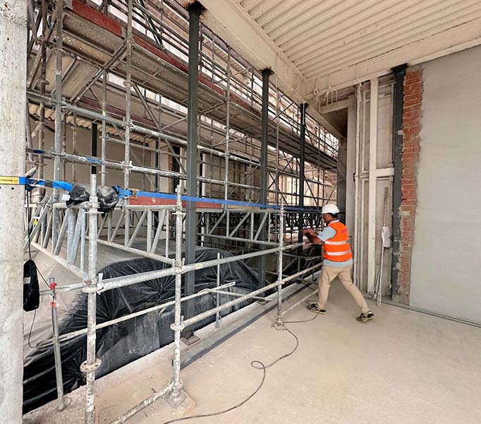 Obra con andamio para el mantenimiento de una escalera mecánica